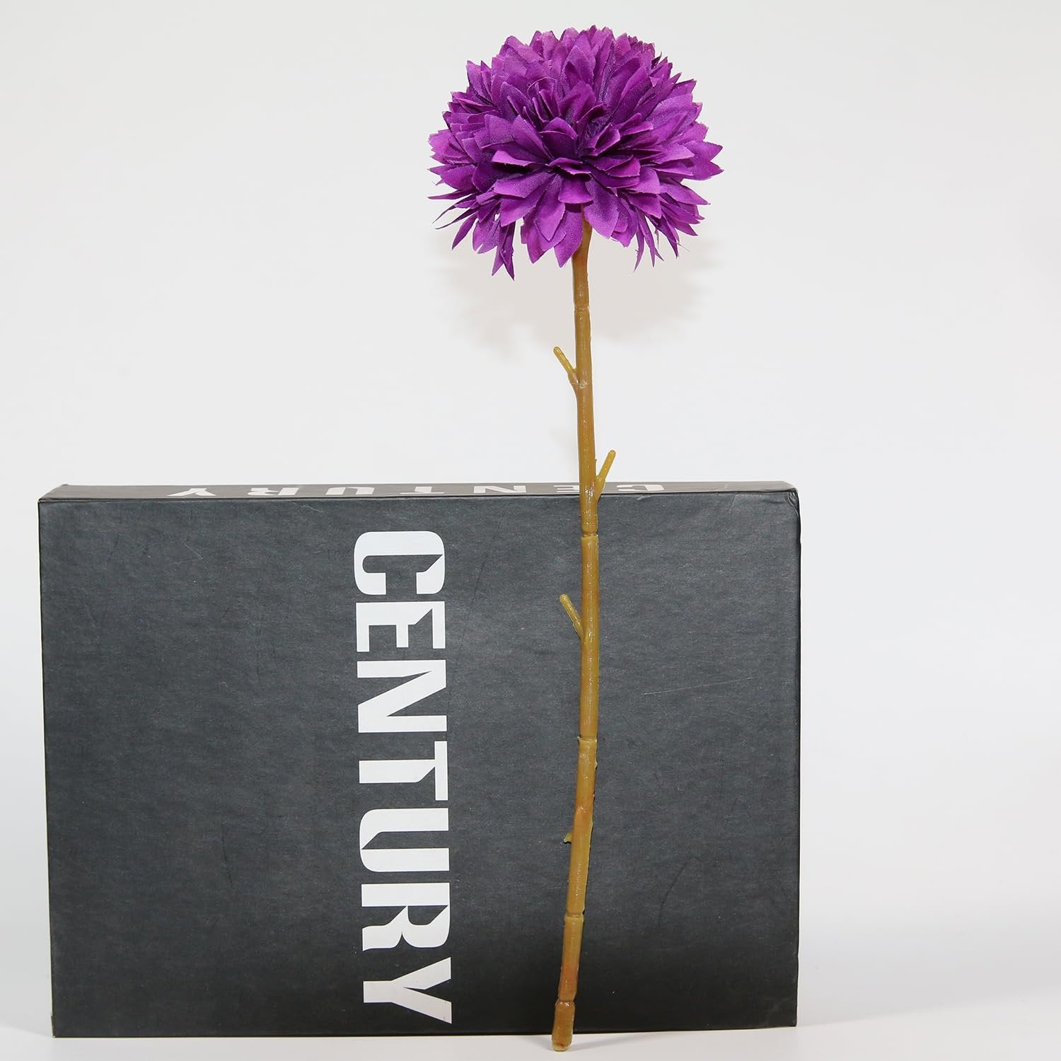 Single purple artificial chrysanthemum flower on a stem, placed in front of a black box with white text.