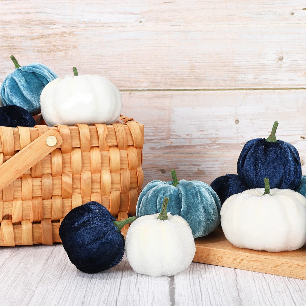 Assortment of blue and white velvet artificial pumpkins in a basket and on a wooden board.
