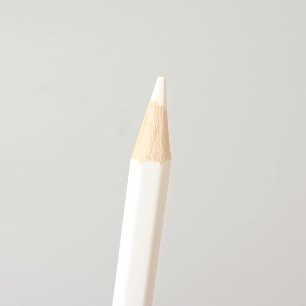 Close-up of a white wood-cased pencil with a sharpened tip against a plain background.