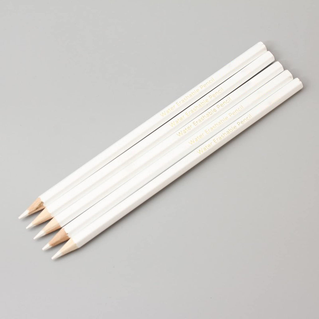Five white water-erasable pencils with sharpened tips arranged diagonally on a gray background.