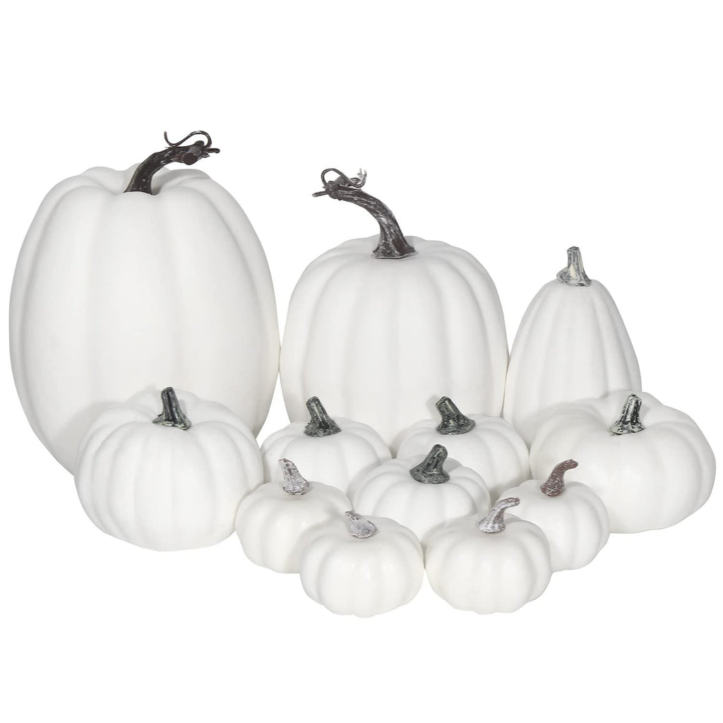 Assorted sizes of white foam artificial pumpkins arranged together on a white background.