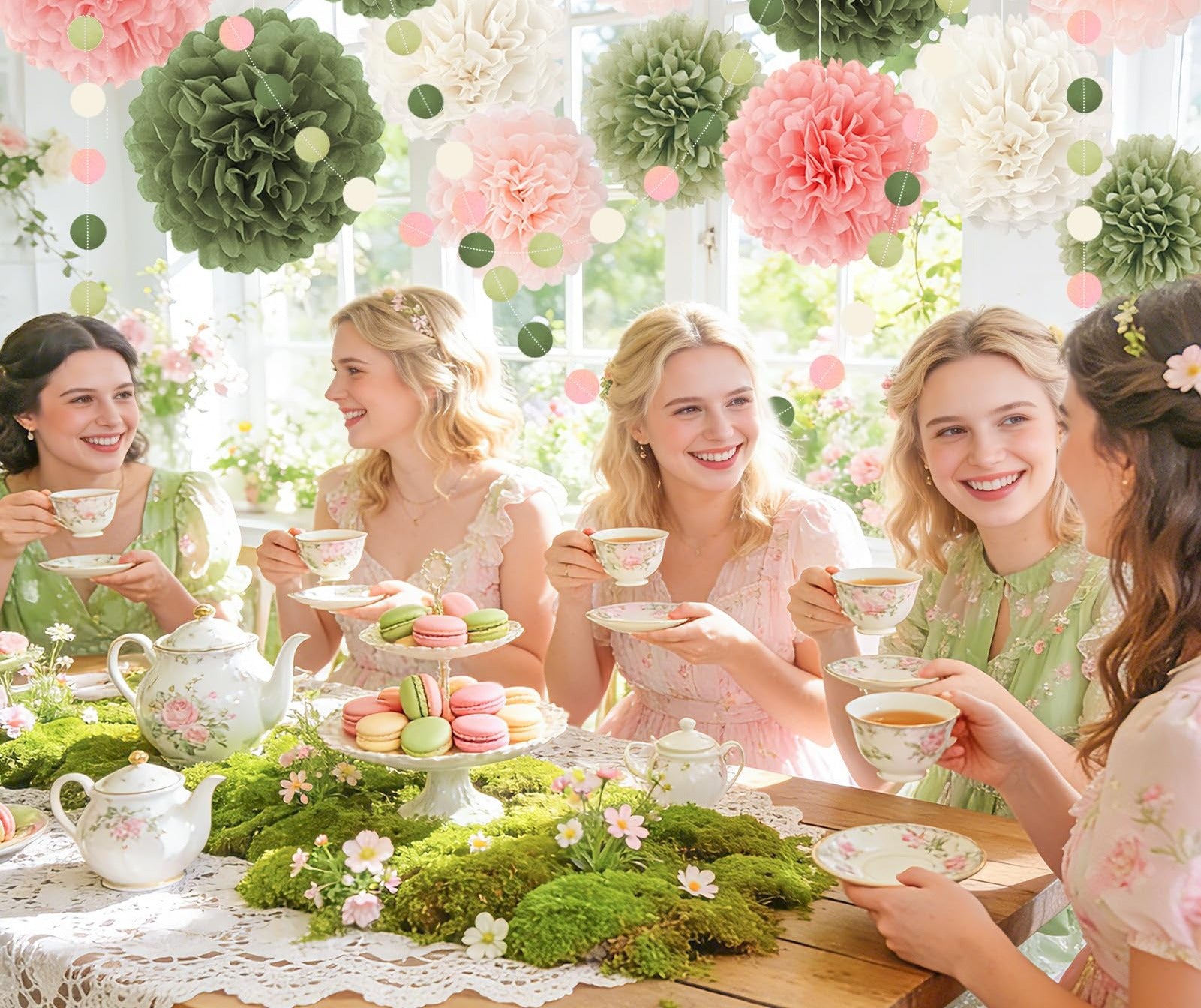Women enjoying tea party with pink and green tissue paper pom poms overhead