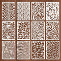 Twelve reusable stencils with assorted animal print and wavy patterns laid out on a wooden background.