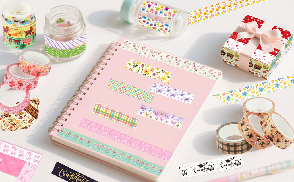 Assortment of decorative washi tape rolls and applied strips on a pink notebook and gift box.