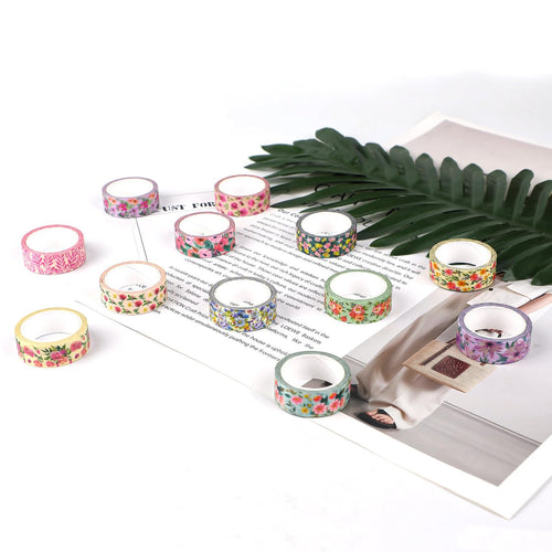 Set of 12 floral washi tape rolls arranged on a magazine with a palm leaf accent.