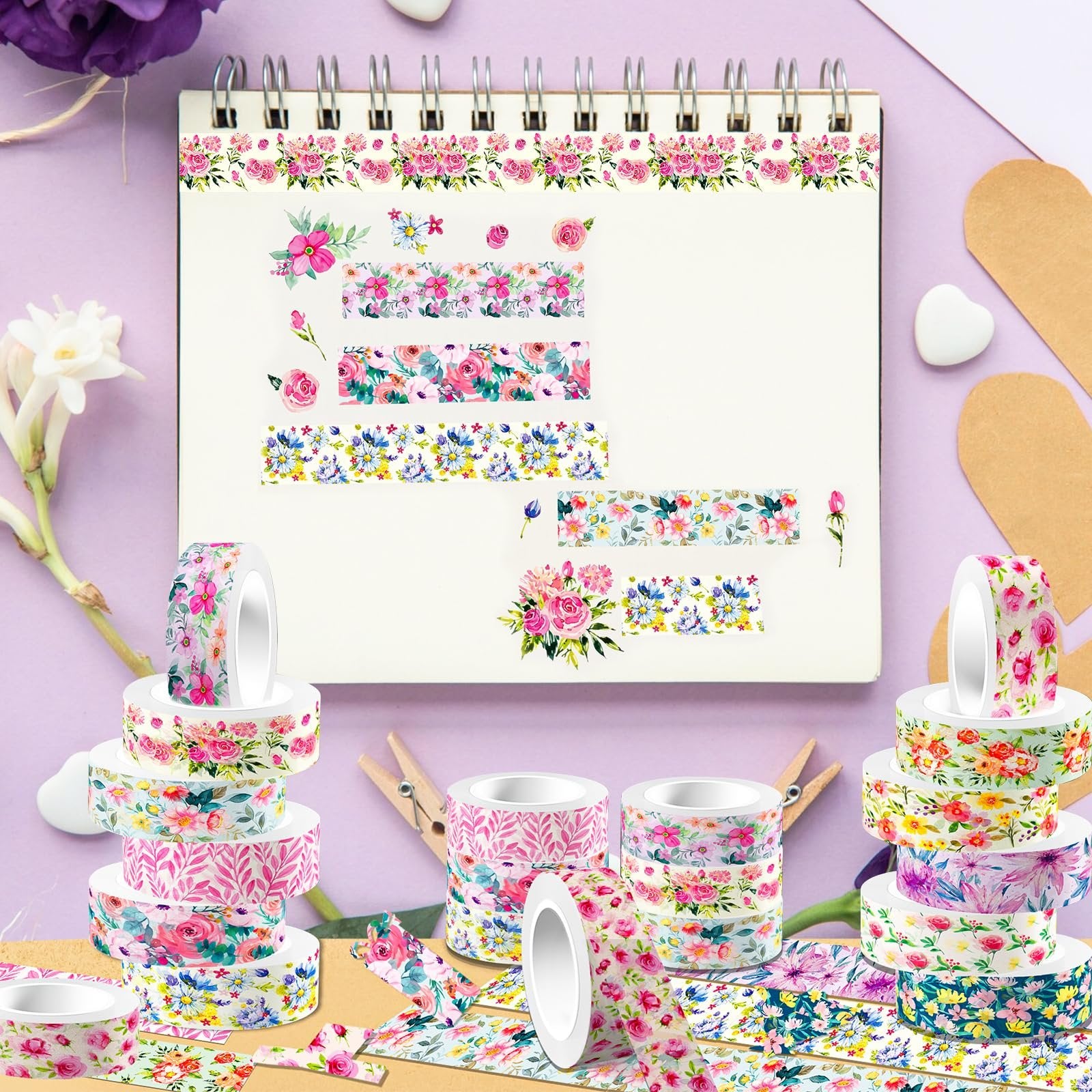 Stack of floral washi tape rolls and loose tape samples on a notebook page with floral designs.