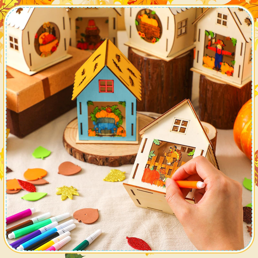 Wooden Thanksgiving house craft kit with watercolor pens and foam stickers, a hand coloring a house.