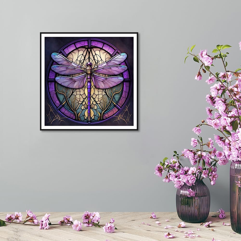 Framed dragonfly stained glass diamond painting art displayed on a wall with flowers in vases.