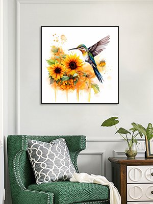 Diamond painting kit featuring a hummingbird hovering over sunflowers, framed and hung on a wall above a green armchair.