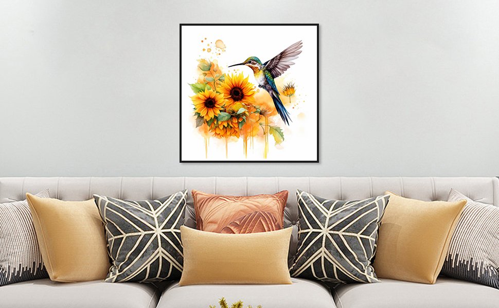 Hummingbird and sunflowers diamond painting kit displayed on a wall above a sofa