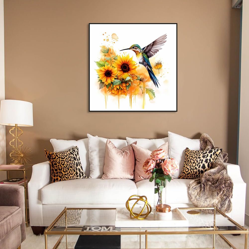 Hummingbird and sunflowers diamond painting artwork displayed above a white sofa in a living room setting.