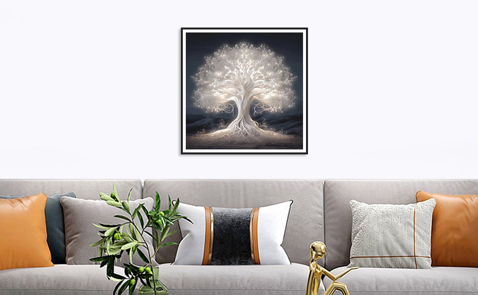 Framed diamond painting of a glowing white tree of life hanging on a wall above a sofa.
