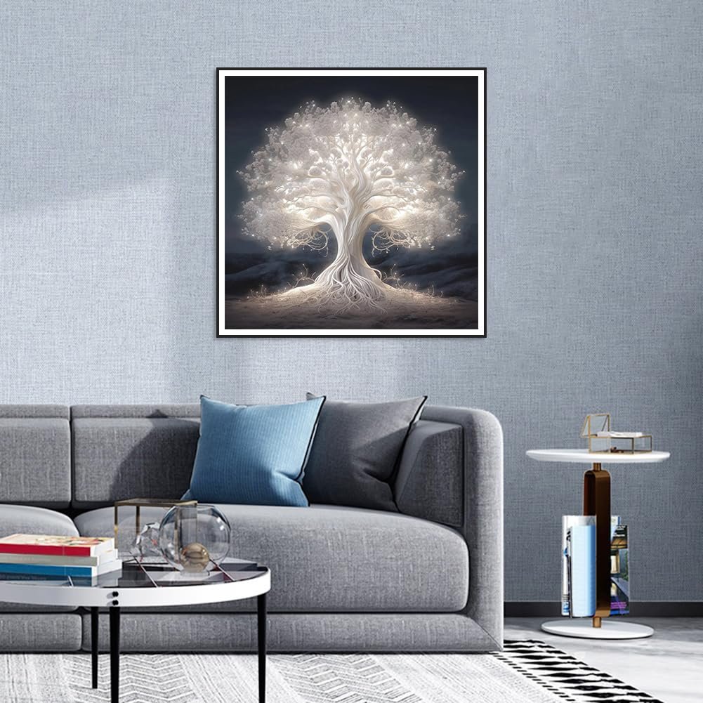 Framed 5D diamond painting of a glowing white tree of life hanging on a wall above a sofa.