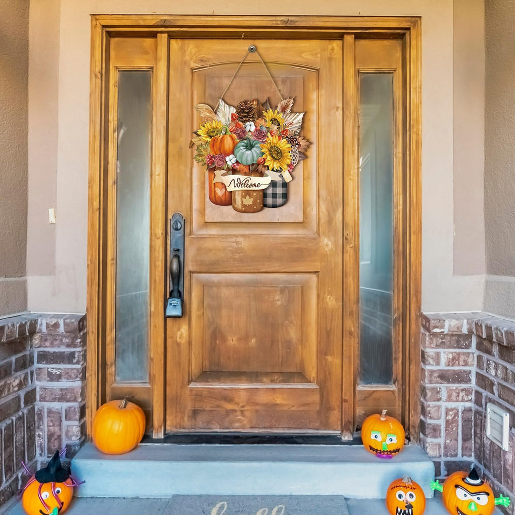 Thanksgiving door sign with pumpkins, sunflowers, and maple leaves hanging on a wooden door, flanked by pumpkins on the porch.