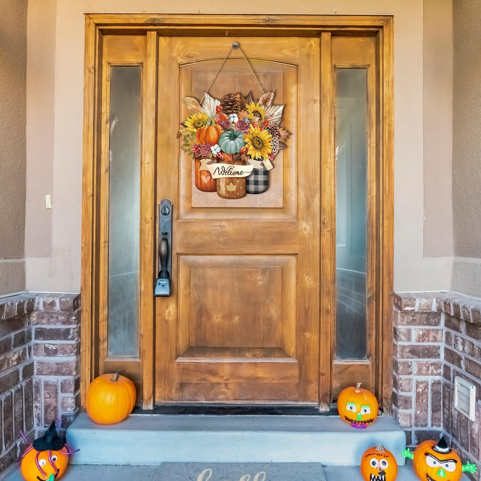 Thanksgiving door sign with pumpkins, sunflowers, and maple leaves hanging on a wooden door, flanked by pumpkins on the porch.