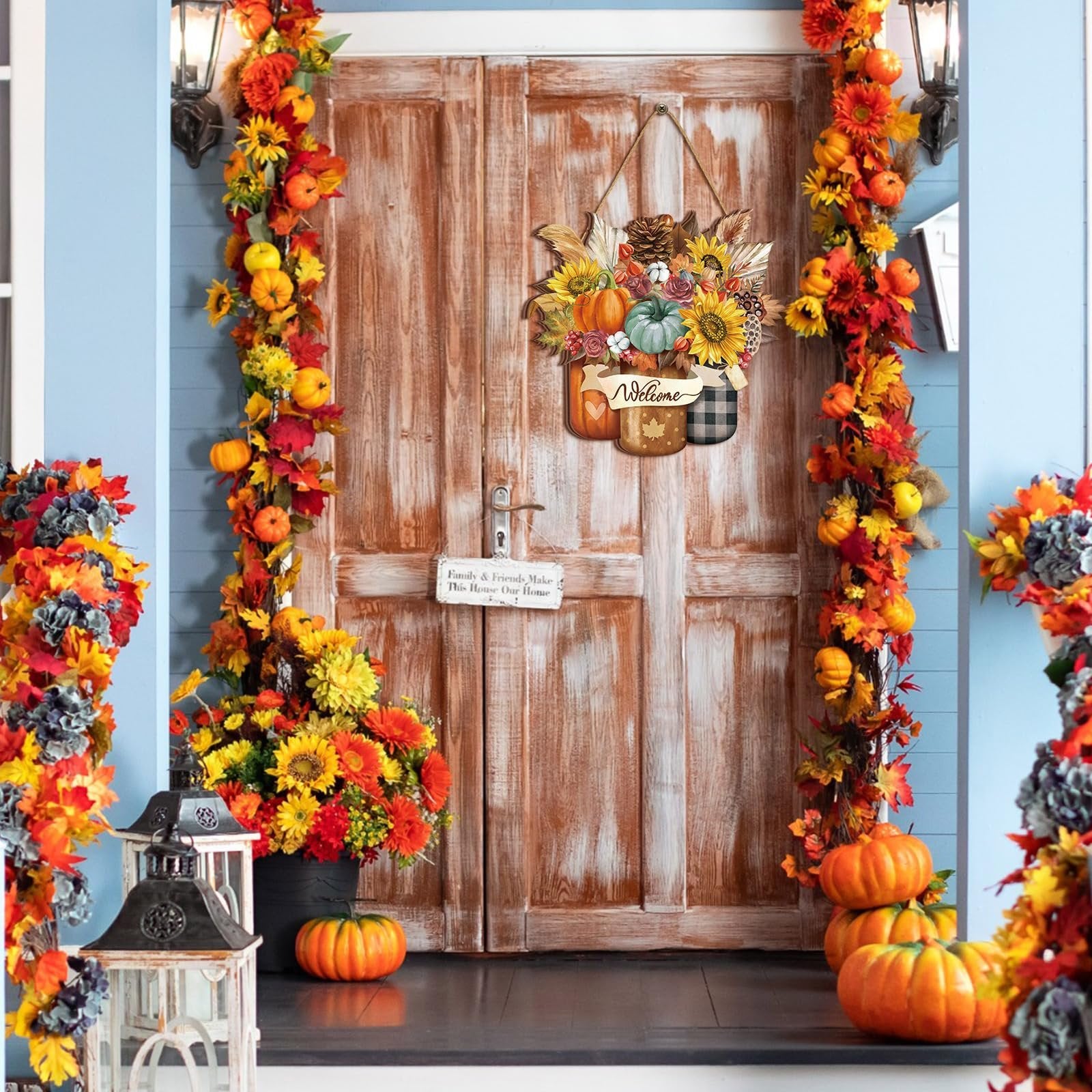 Front door decorated for fall with a hanging sign featuring pumpkins, sunflowers, and pinecones.