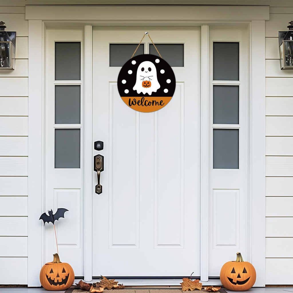 Round Halloween welcome sign with ghost and pumpkin hanging on a white front door.