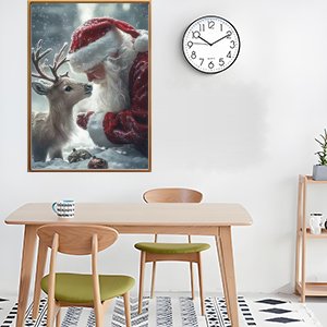 Framed 5D diamond art painting of Santa Claus and a reindeer in a snowy forest, displayed on a wall above a dining table.