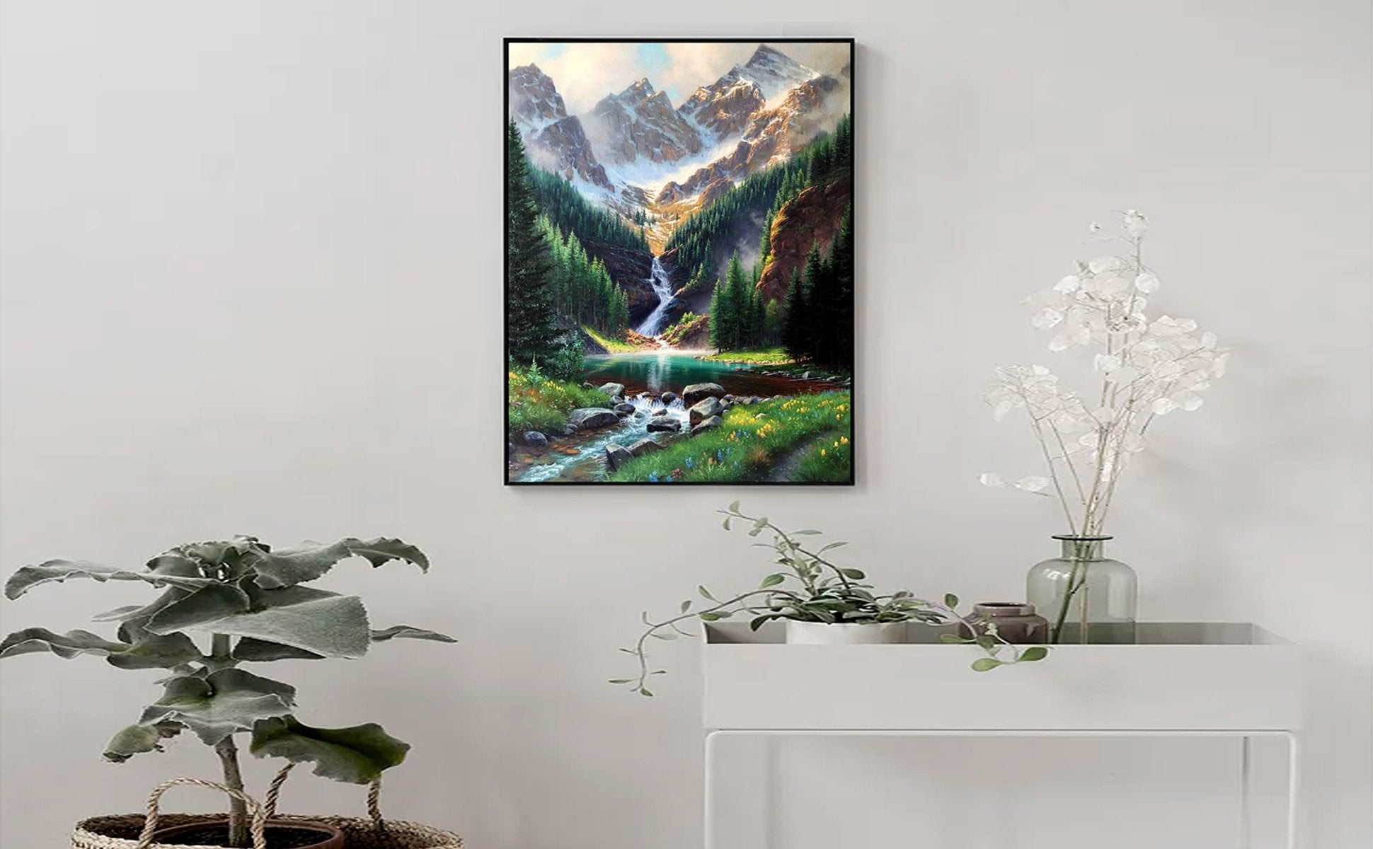 Framed 5D diamond painting of a mountain waterfall landscape with trees and a stream, displayed on a white wall.