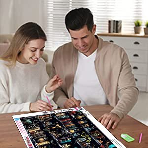 Couple working on a 5D diamond painting kit featuring a goth skull design, with tools and gems laid out.
