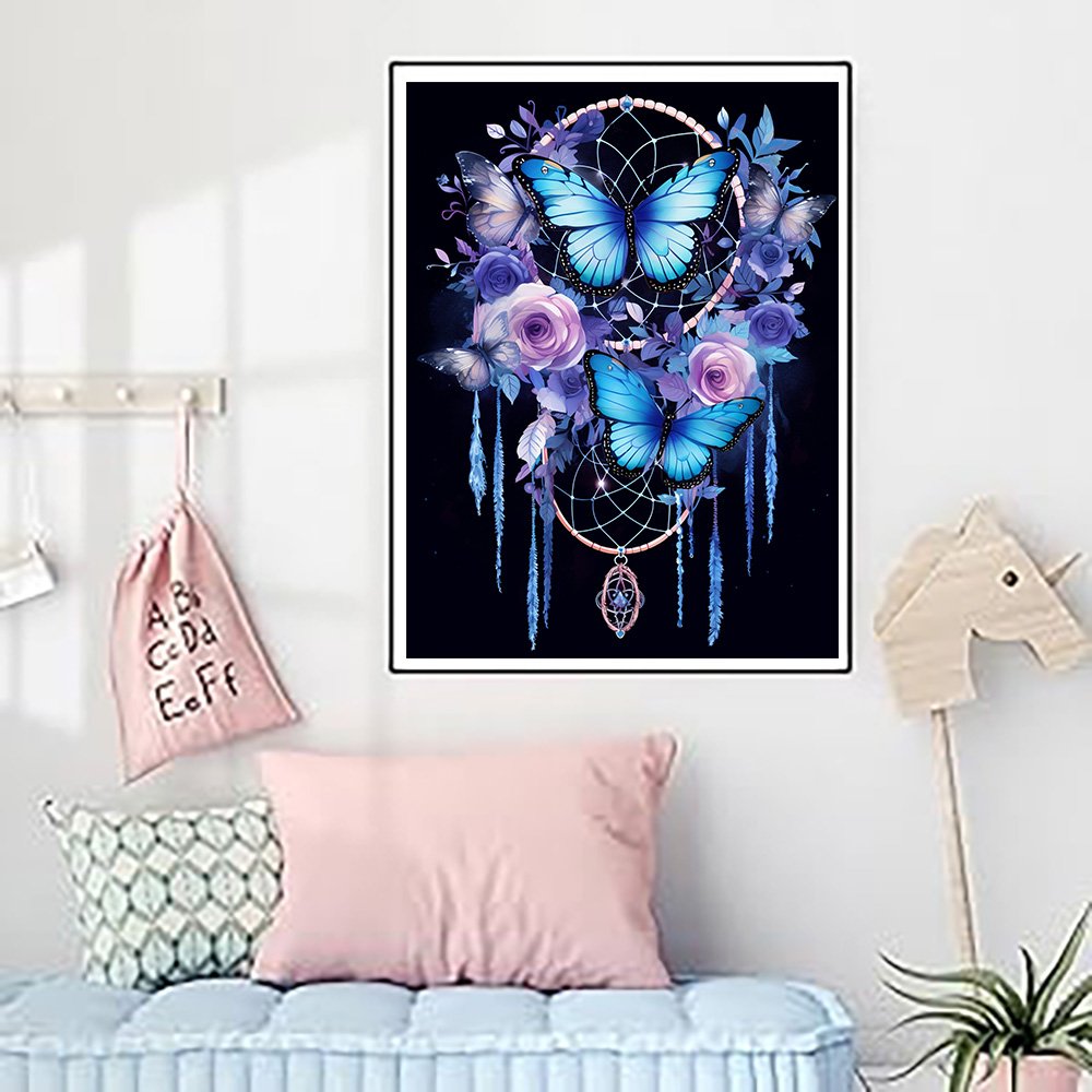 Diamond art painting of a dreamcatcher with blue butterflies and purple roses on a black background.