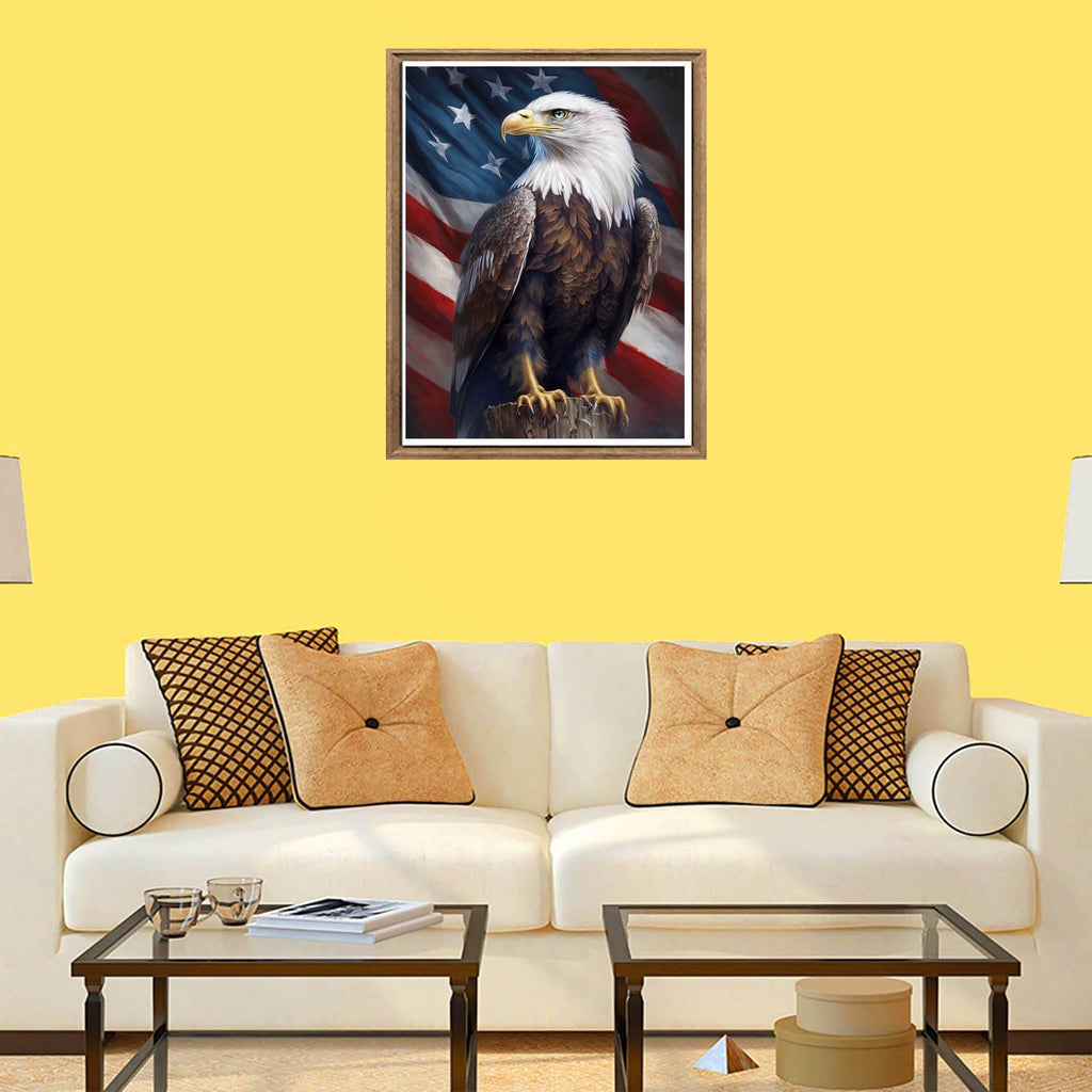 Diamond painting kit featuring a bald eagle perched on a wooden post against the backdrop of the American flag, displayed in a living room setting.