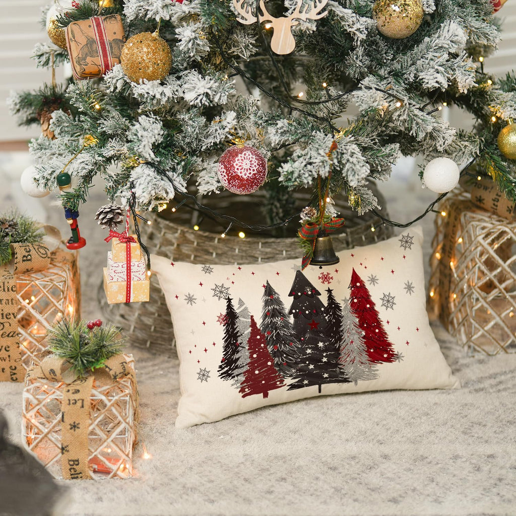 Christmas throw pillow cover with red and black trees and snowflakes, placed under a decorated Christmas tree.