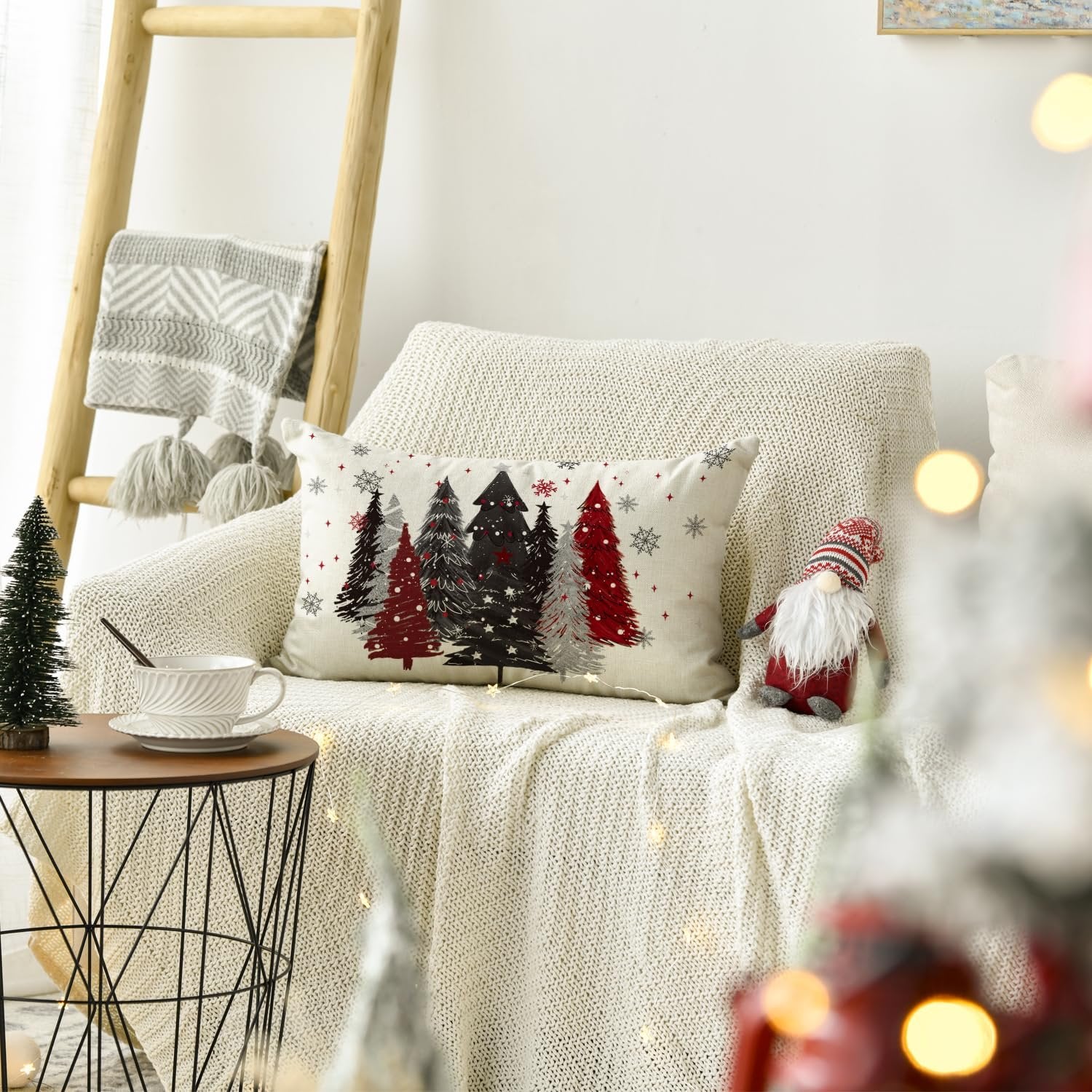 Christmas throw pillow cover with red and black trees and snowflakes on a couch with a blanket and gnome