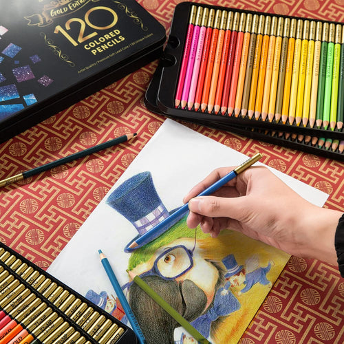 A hand holding a blue colored pencil and drawing on a paper featuring a parrot wearing a hat, with a tin of 120 colored pencils open nearby.