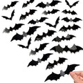 Black 3D bat wall decals in various sizes, with a hand placing one on a surface.