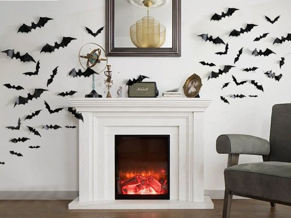 Black 3D Halloween bat wall stickers in various sizes decorating a fireplace and wall.