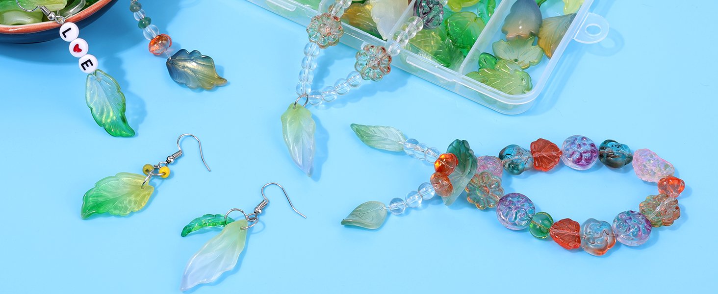 Assortment of Czech glass leaf beads and finished jewelry pieces on a blue background
