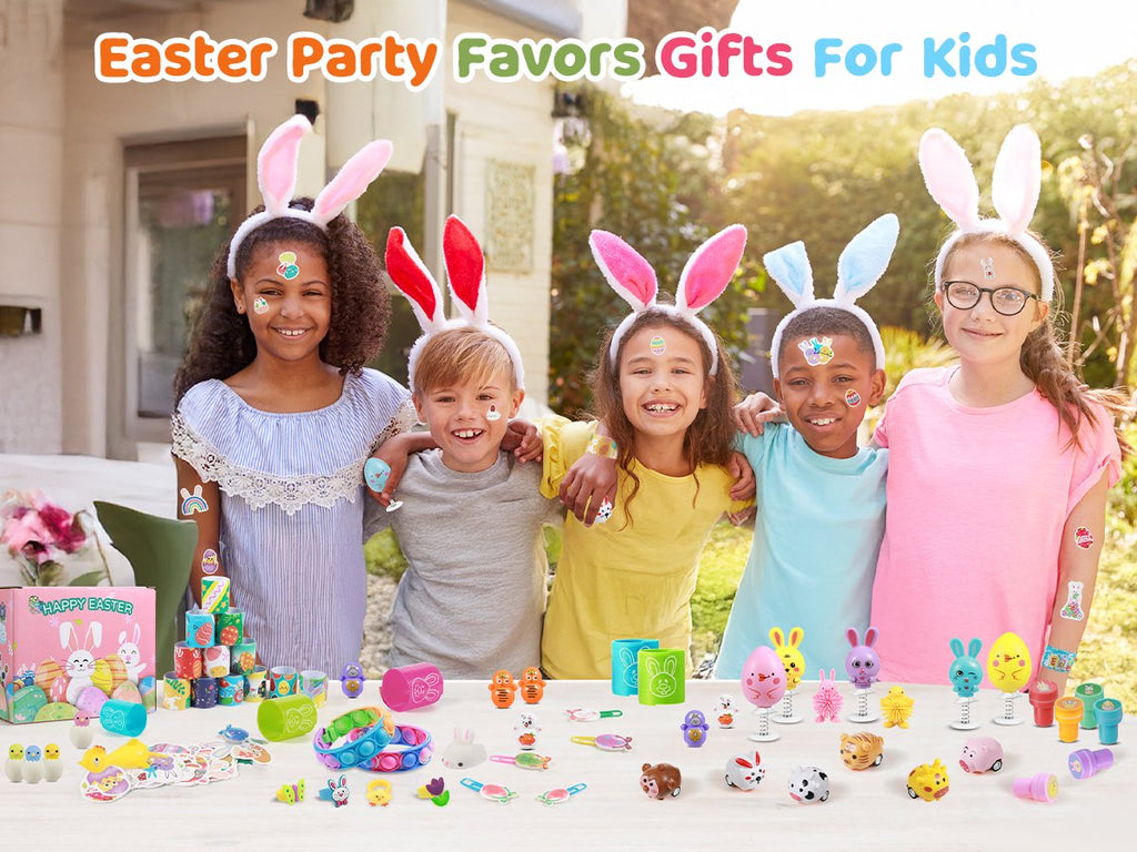 Four smiling children wearing Easter bunny ears, with various Easter toys displayed on a table in front of them.