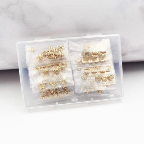 Gold plated heishi and rondelle spacer beads in 12 styles, organized in a clear plastic case for jewelry making.