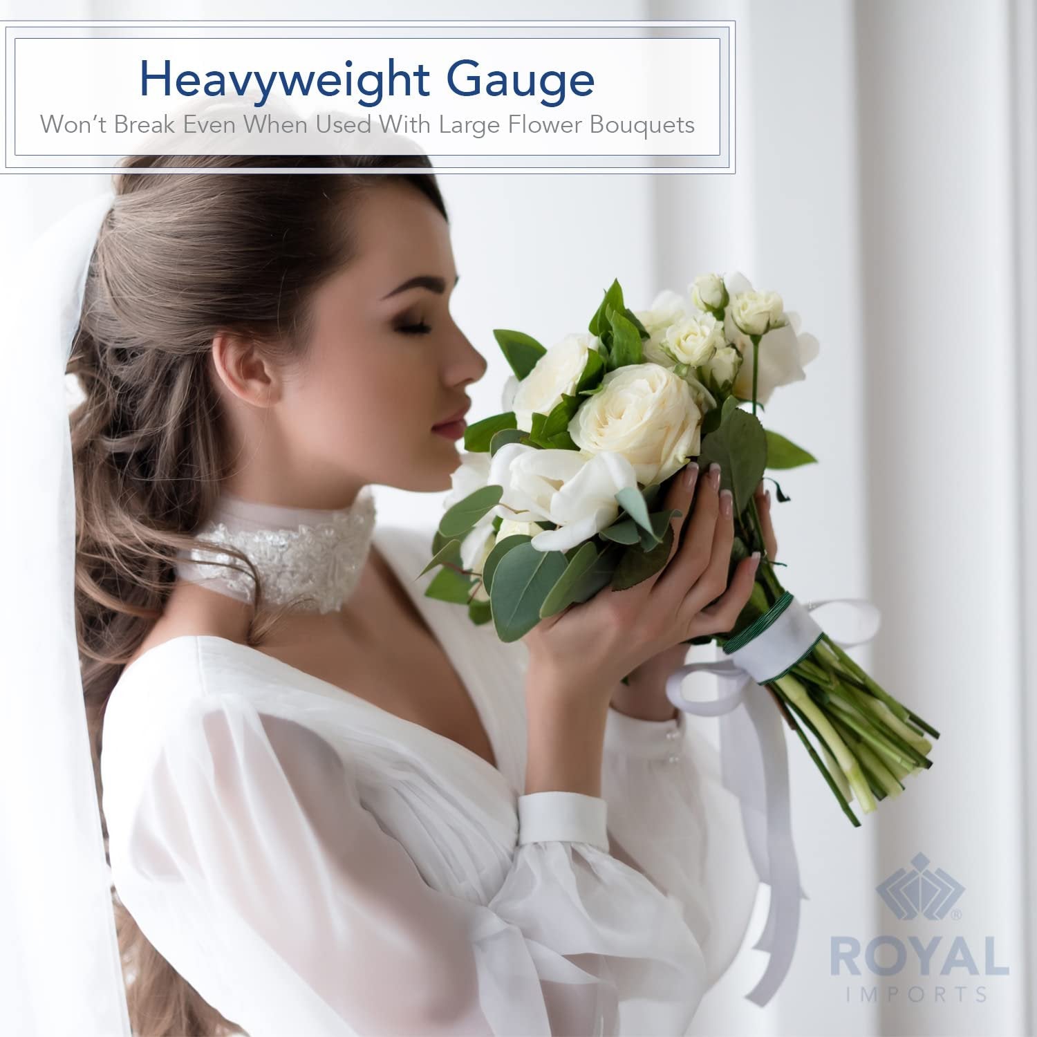 Bride smelling white roses bouquet with green bind wire and white ribbon