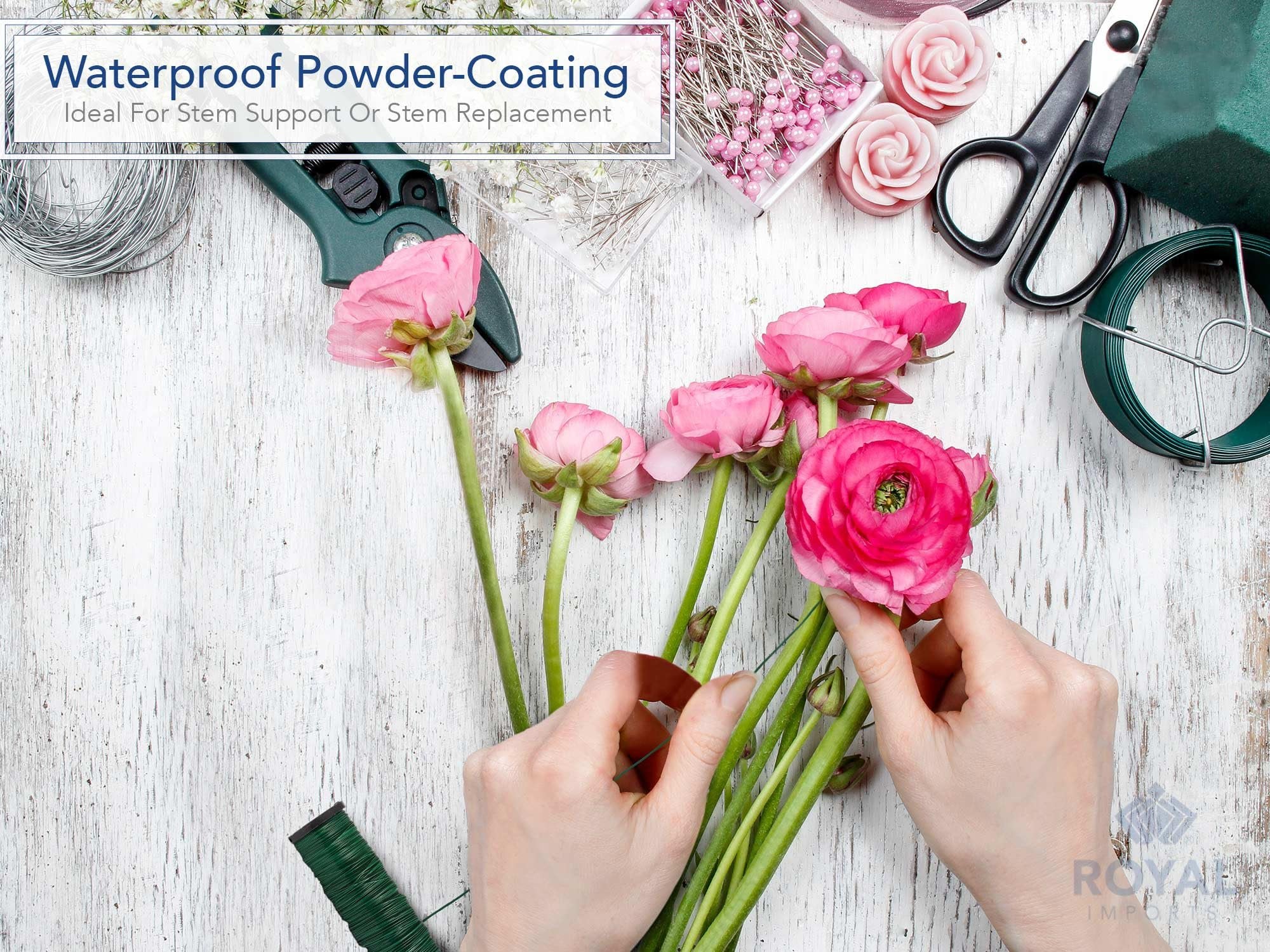 Hands arranging pink flowers with floral wire, scissors, and spools of wire on a white wooden surface.