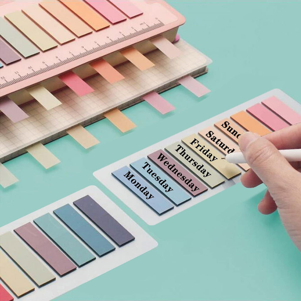Morandi sticky note tabs with days of the week labels being applied to a notebook page