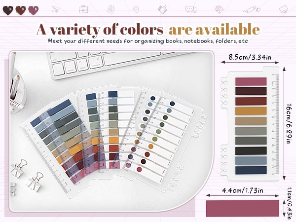 Set of translucent annotation tabs in multiple colors and designs, displayed on a desk with a keyboard and binder clips.