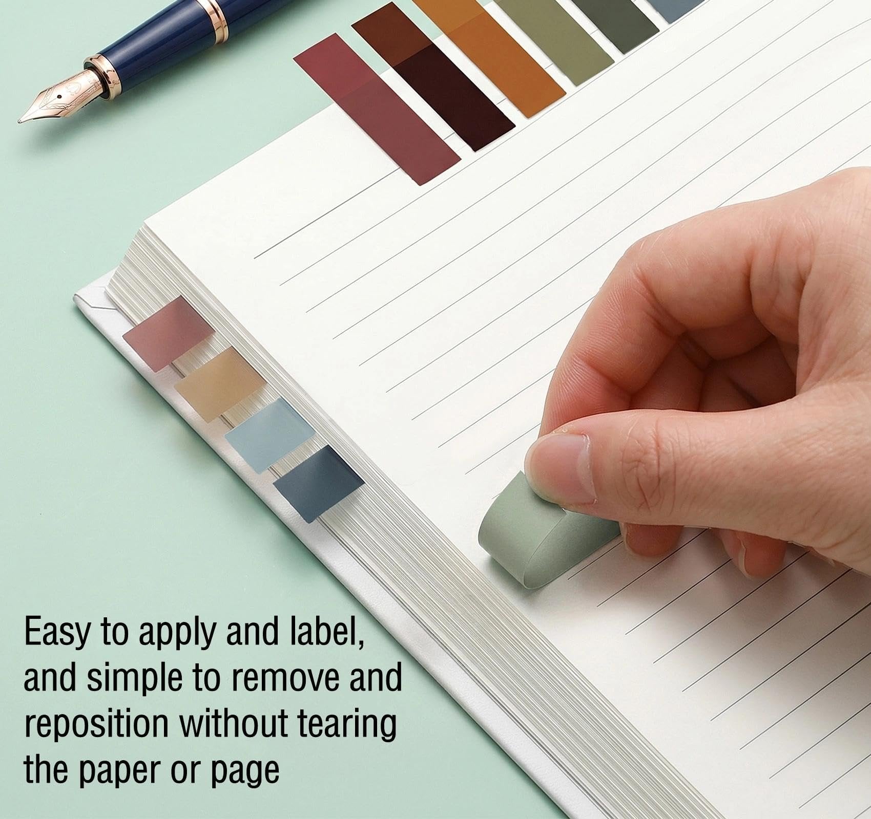 Close-up of translucent annotation tabs being applied to a lined notebook page with a pen and eraser nearby.