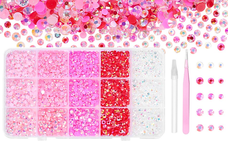Pink and red resin rhinestones in a divided container with tweezers and a pickup tool, scattered rhinestones above.