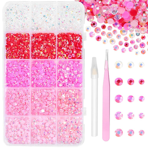 Pink and clear resin jelly rhinestones in a divided container with a pink tweezer and white pickup tool.