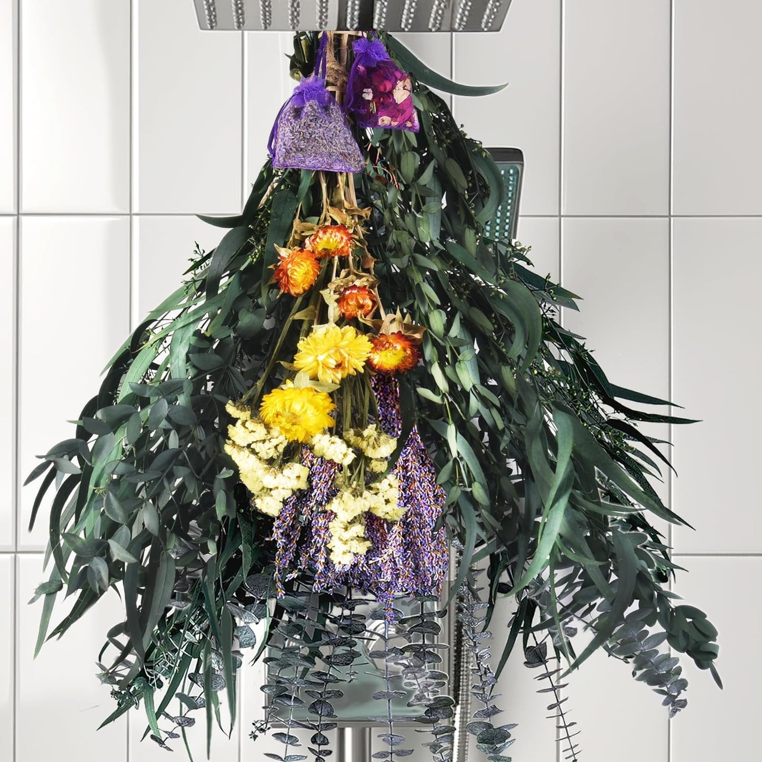 Dried eucalyptus and lavender bouquet hanging from a shower head with small sachets.