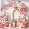 Dusty pink balloon arch garland kit with various sizes of latex, confetti, and metallic balloons, accented with floral arrangements.