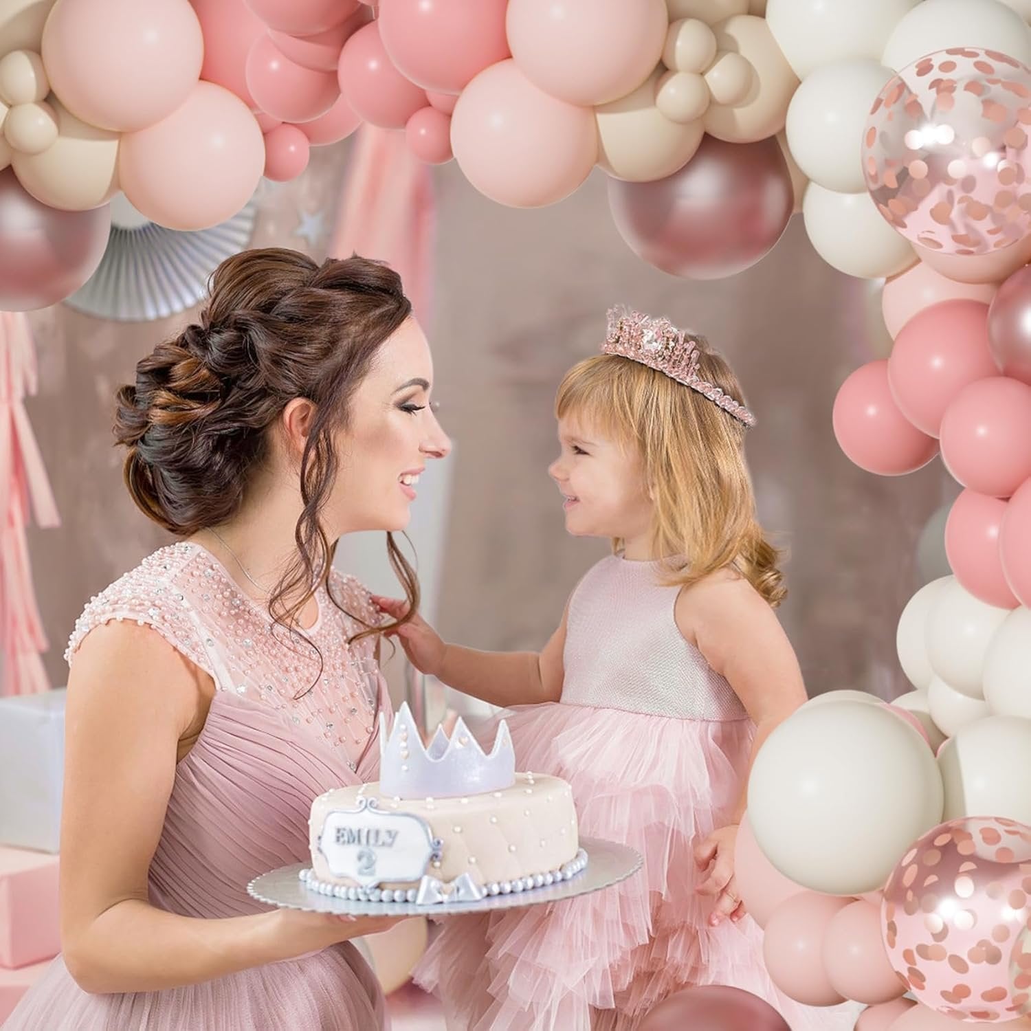 Mother and daughter celebrating with a cake and balloons, dusty pink and rose gold theme