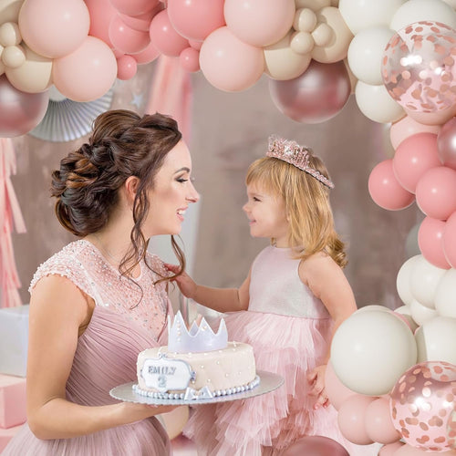 Mother and daughter celebrating with a cake and balloons, dusty pink and rose gold theme