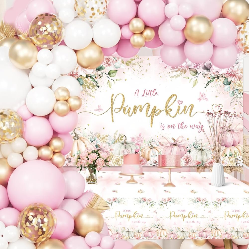 Pink and gold balloon garland arch over a baby shower backdrop with pumpkins and floral accents, featuring a tablecloth with matching design.