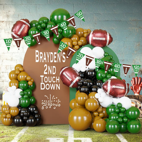 Football-themed balloon arch with footballs, pennant banners showing yard lines, and text 'BRAYDEN'S 2ND TOUCH DOWN'.