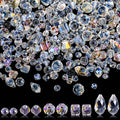 Assortment of faceted glass beads in various shapes and sizes with AB finish on a black background, showing five distinct shapes at the bottom.