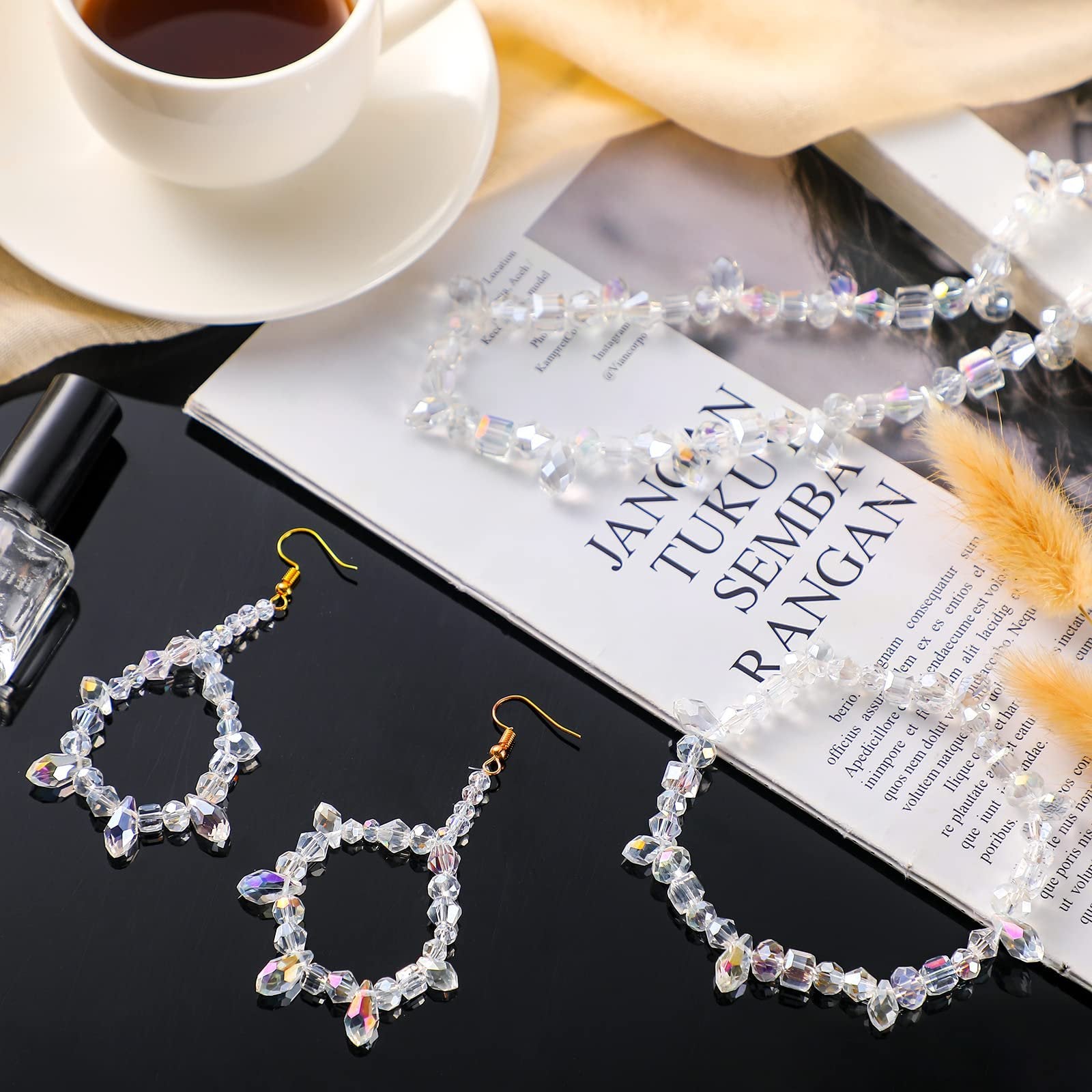 Faceted glass bead earrings and necklace with AB finish, displayed with a cup of tea and a magazine.