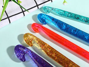 Set of five large crochet hooks with glitter-filled transparent handles in purple, yellow, orange, blue, and green.
